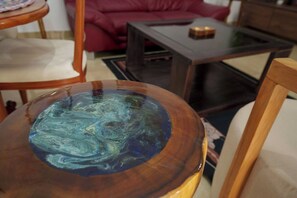A round wooden table with a glass top featuring a blue and green marbled pattern. - Tita, T2 piscine & charme africain (Abidjan)