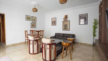 Ein Wohnzimmer mit Sofa, Sesseln, Couchtisch und Wandbildern.