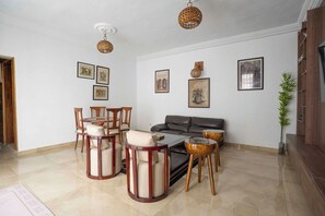 A living room with a sofa, chairs, a coffee table, and wall art. - Ina, votre beaux T2 lumineux avec piscine (Abidjan)