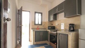 Una cocina moderna con armarios oscuros, microondas, estufa y refrigerador.