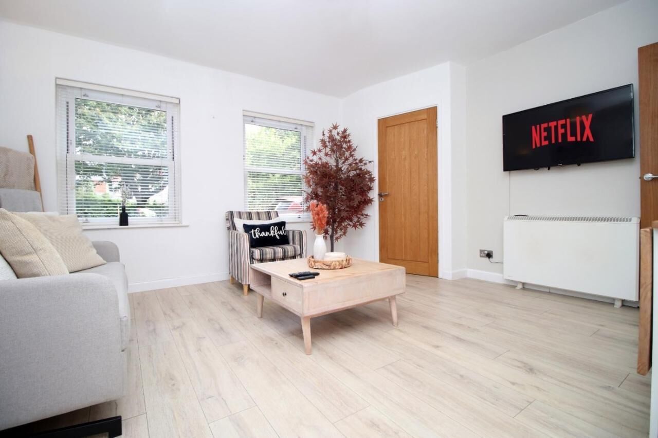 Un salon moderne avec un canapé, une table basse, un téléviseur et une porte.