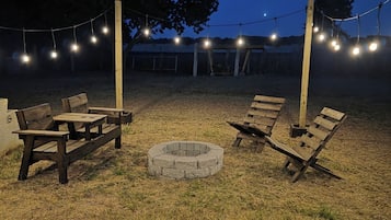 Un espace extérieur aménagé avec des bancs en bois et un foyer.