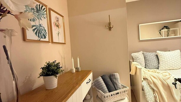 Un dormitorio con cama, mesita de noche y espejo.