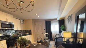 Una cocina moderna con microondas, estufa y comedor con candelabro.