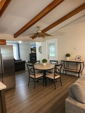 A modern kitchen with a dining area, wooden ceiling beams, a ceiling fan, and a refrigerator. - 3-bedroom house in delightful Toledo with cool AC and comfort great Location (Toledo)