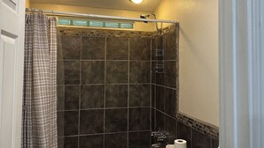 Un bagno con doccia, servizi igienici e lavandino.