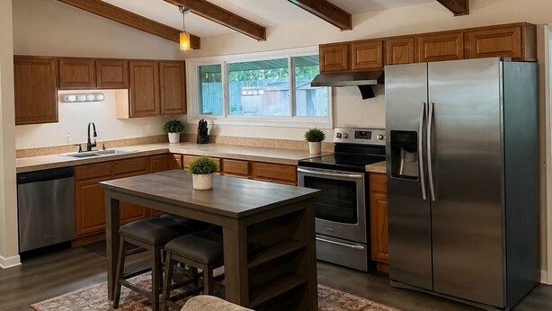 A modern kitchen with wooden cabinets, a stainless steel refrigerator, and a dining area with a table and chairs.