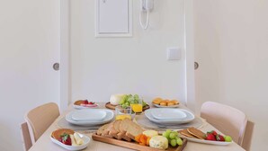 A dining table with plates, cutlery, and a variety of food items. - 3 Apartments with Swimming Pool by HostWise (Moreira)