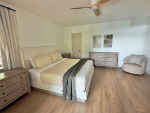 A bedroom with a bed, dresser, chair, and ceiling fan. - Sunset Cove — Lake Keowee Luxury Retreat with Private Dock + Hot Tub (Seneca)
