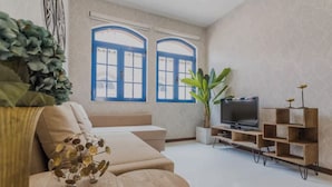 A modern living room with a sofa, a TV, and a plant. - Tagus View Penthouse · Triplex with Private Terrace (Lisboa)