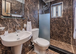 A modern bathroom with a marble sink, toilet, and a glass shower enclosure. - Prince Anoush Dahabiya 3 Nights  (Luxor)