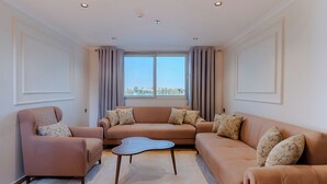 A modern living room with a beige sofa, a matching armchair, and a coffee table. - Prince Anoush Dahabiya 3 Nights (Luxor)