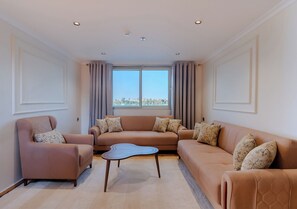 Una sala de estar moderna con un sofá beige, un sillón a juego y una mesa de centro.