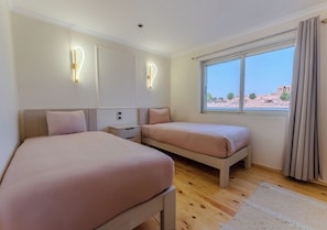 A bedroom with two beds, a nightstand, a bedside table, a window with curtains, and a view of the outside. - Prince Anoush Dahabiya 3 Nights  (Luxor)