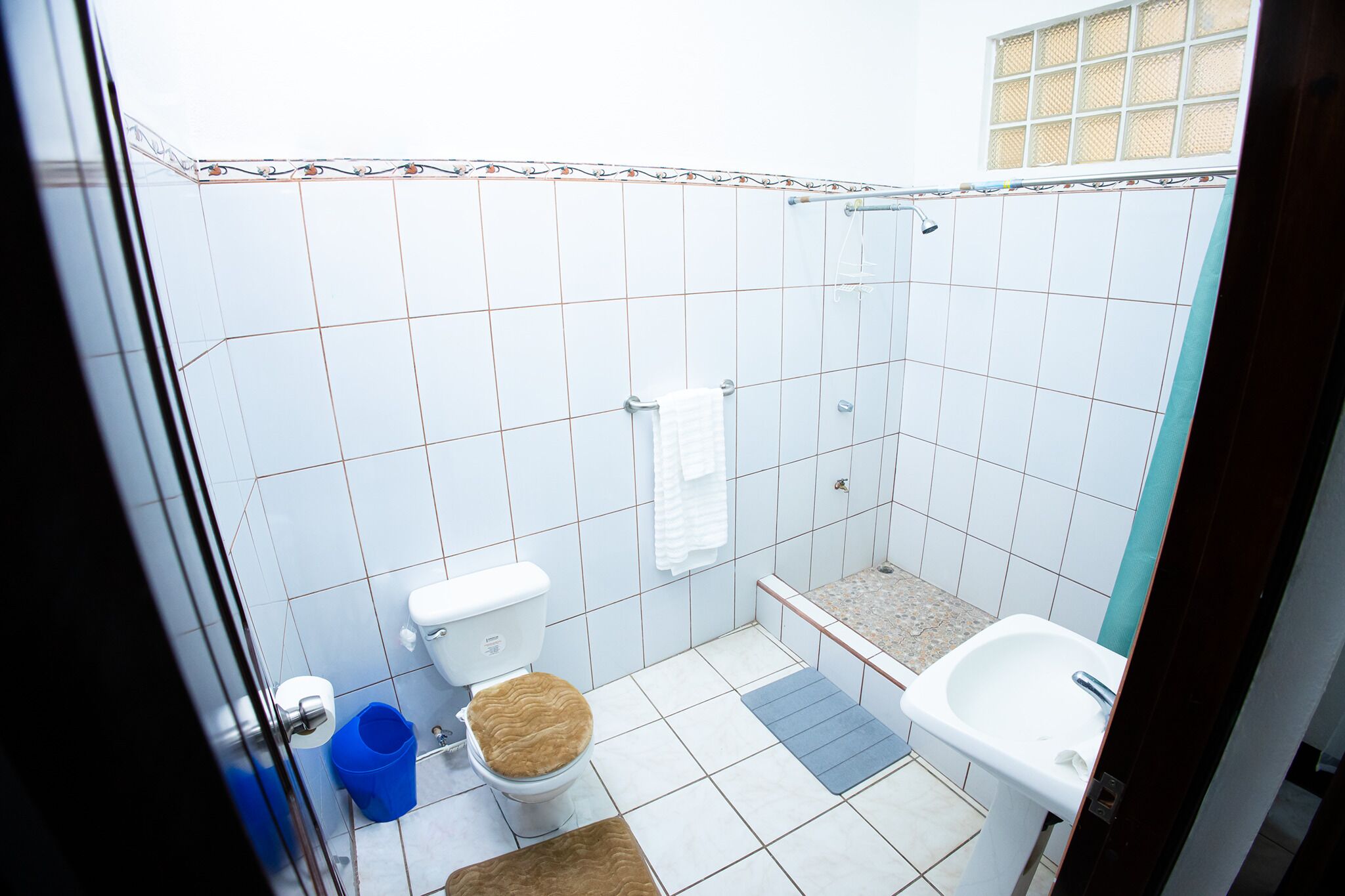 Pieni kylpyhuone, jossa on wc, suihku ja pesuallas.