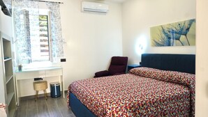A bedroom with a bed, a chair, a desk, and a window with curtains. - Break at Sea (Castellabate)