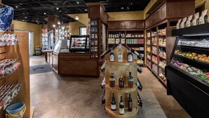 A grocery store interior with a central display of liquor bottles, refrigerated produce, and shelves stocked with packaged goods. - St. Thomas 3 Bedroom Villa at Resort w/Amenities (St Thomas)