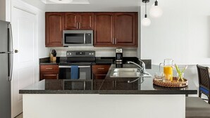 A modern kitchen with dark wood cabinets, stainless steel appliances, and a granite countertop. - St. Thomas 3 Bedroom Villa at Resort w/Amenities (St Thomas)