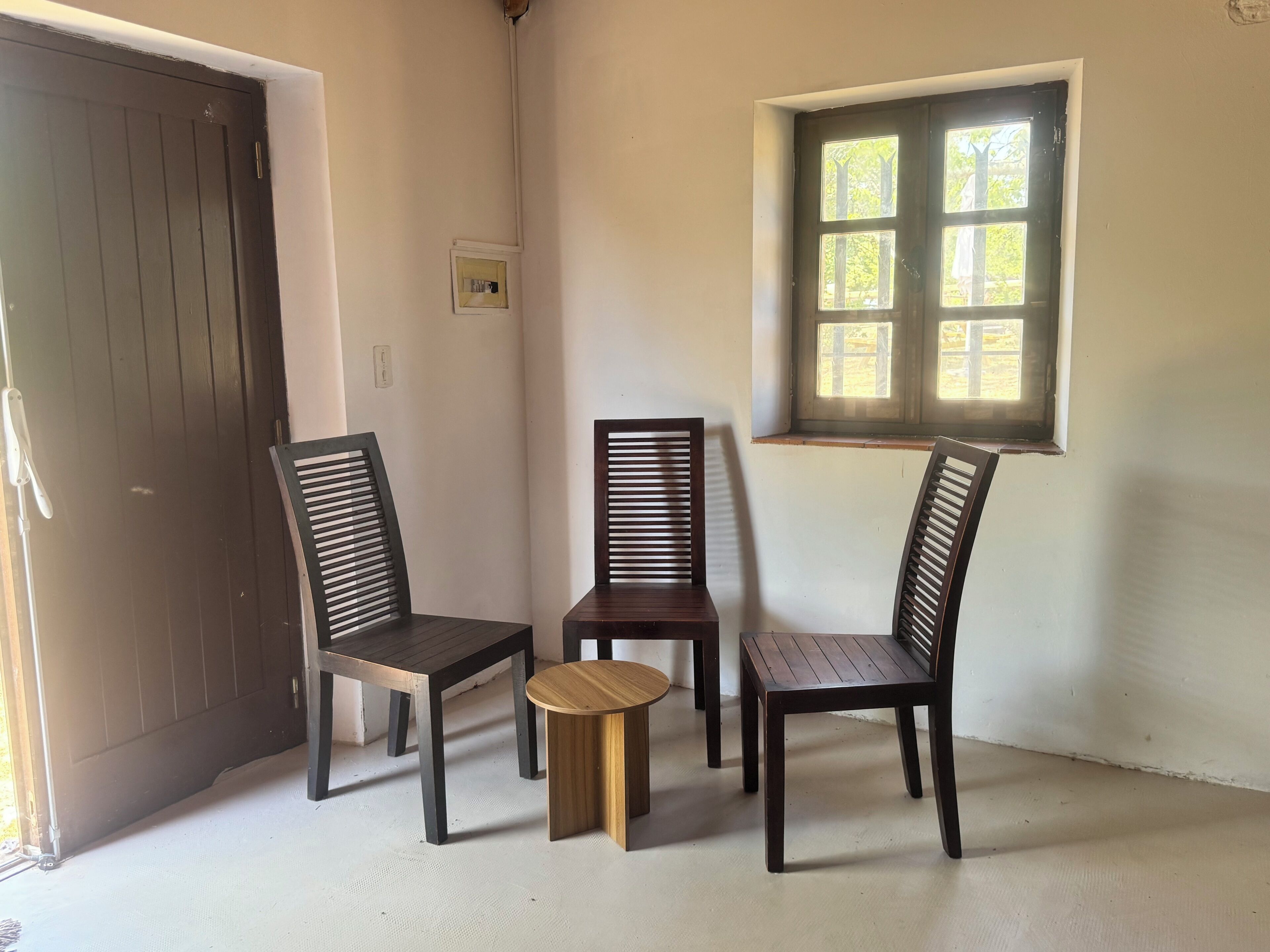 A room with a door, a window, and three chairs.