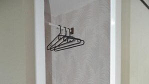 A bathroom with a shower enclosure, a towel rack, and a patterned shower curtain. - Hostal Marbella 47 (Cartagena)