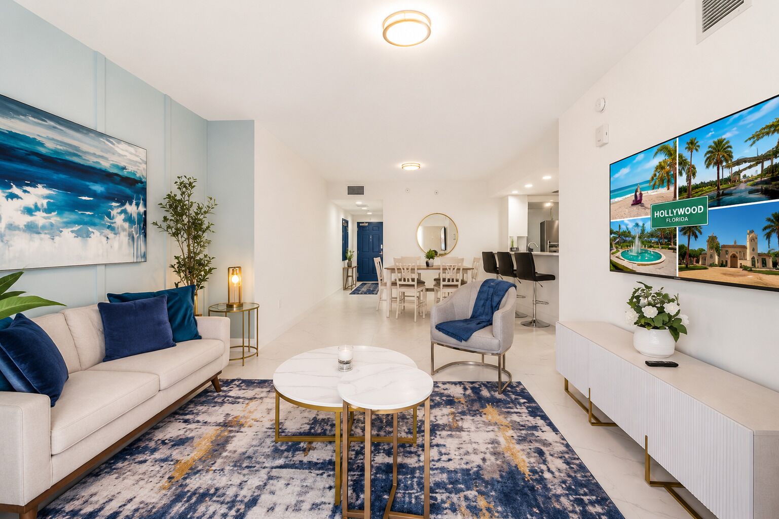 A modern living room with a sofa, coffee table, and a dining area with chairs and a table.