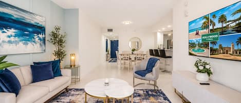 Un salon moderne comprenant un canapé, une table basse et un coin repas avec des chaises et une table.