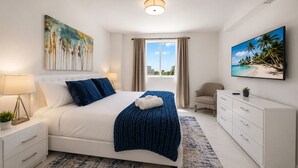 Un dormitorio moderno con cama, mesitas de noche, un escritorio y una silla.
