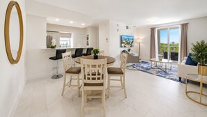 Una sala de estar moderna con comedor, cocina y balcón con vistas.
