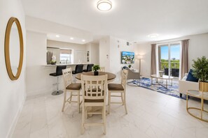 Ein modernes Wohnzimmer mit Essbereich, einer Küche und einem Balkon mit Blick.