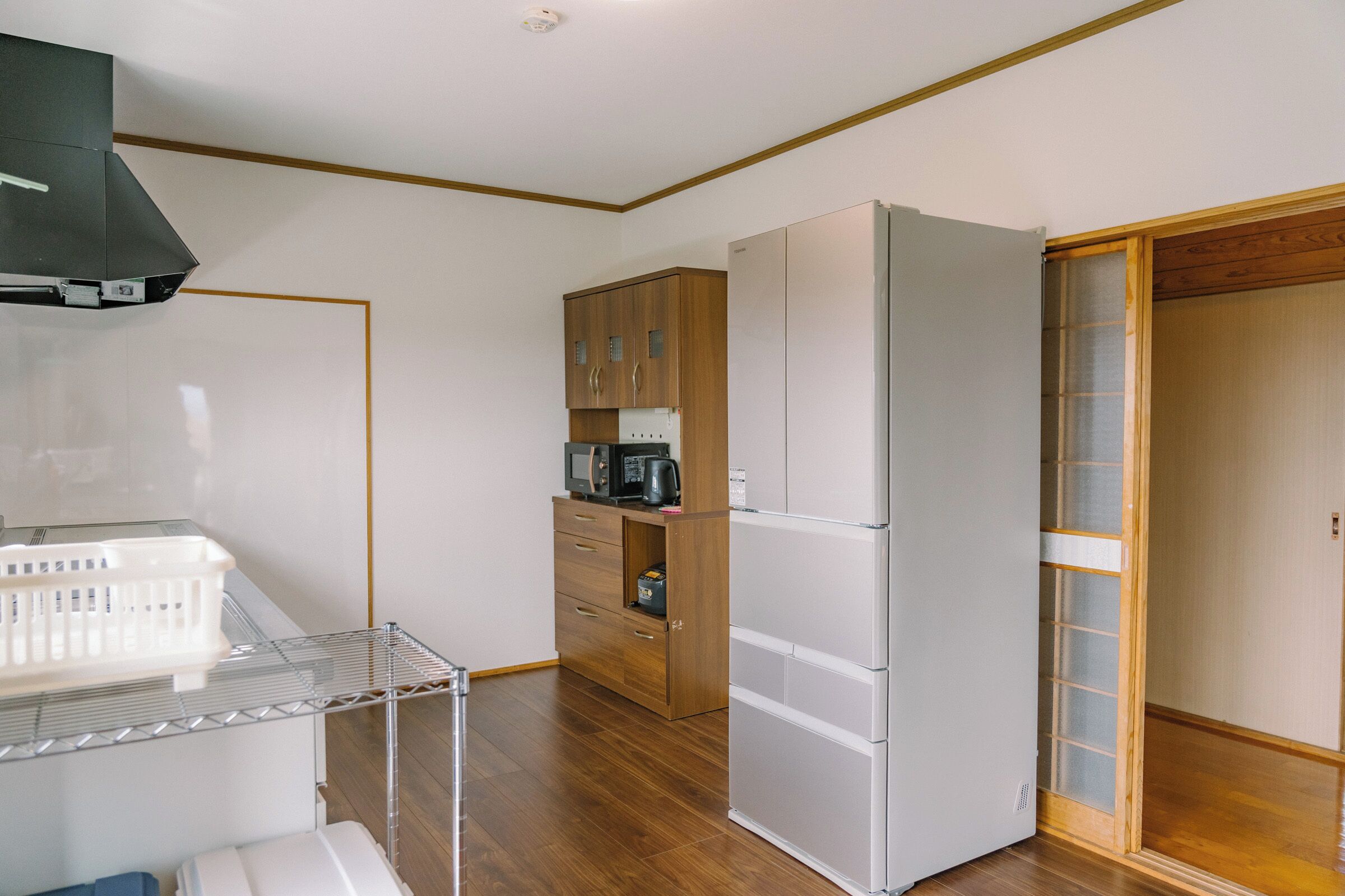A compact kitchen with a microwave, refrigerator, and wooden cabinets.