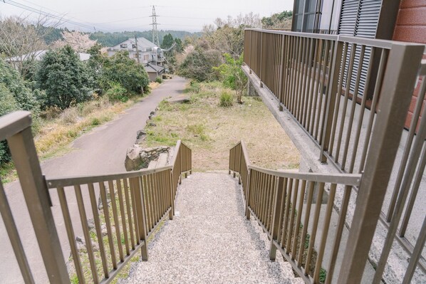 Un sendero que conduce a una zona residencial con casas y una línea eléctrica al fondo.