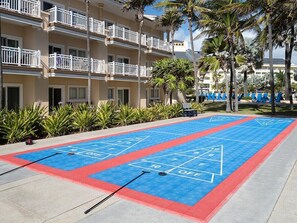 Un terrain de jeu de shuffleboard avec un bâtiment en arrière-plan.