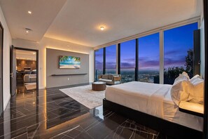 A modern bedroom with a large bed, a TV, and a city view. - Luxury Sky Penthouse with Ocean & City Views (Miami)