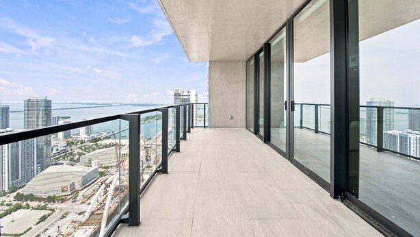 Varanda moderna com vista para o horizonte urbano e para a água.