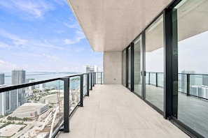 Ein moderner Balkon mit Blick auf eine Stadtlandschaft und ein Gewässer.