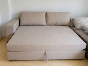 Een bed met hoofdeinde, voeteinde en dekbed.