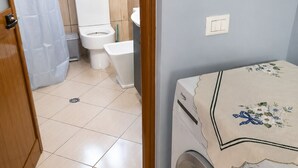A laundry room with a washing machine, a toilet, and a sink. - A holiday home in a quiet neighborhood 5 minutes walking distance from the sea. (Vlora)