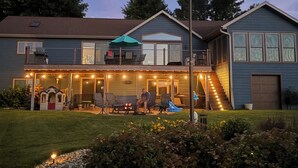 A residential house with a front deck, outdoor seating, and a flagpole. - Lake home retreat in the heart of Okoboji (Milford)