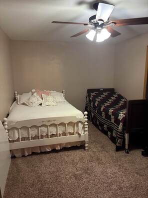 A bedroom with a single bed, a ceiling fan, and a small desk. - Lake home retreat in the heart of Okoboji (Milford)