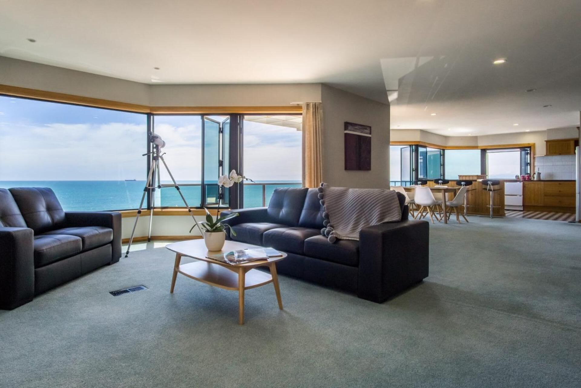 Un'ampia zona giorno con vista mare, una zona pranzo e una cucina.