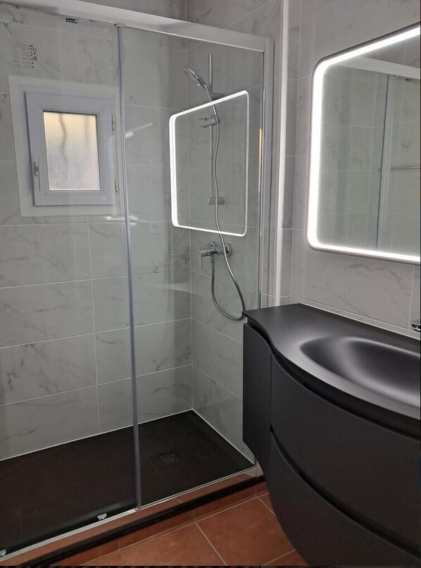 A modern bathroom with a glass-enclosed shower, a black vanity, and a mirror with integrated lighting. - Cornazur: Ocean View, Pool, and Reversible Air Conditioning (ROQUEBRUNE SUR ARGENS)