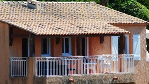A building with a tiled roof, a balcony with white railing, and a window with a white frame. - Cornazur: Ocean View, Pool, and Reversible Air Conditioning (ROQUEBRUNE SUR ARGENS)