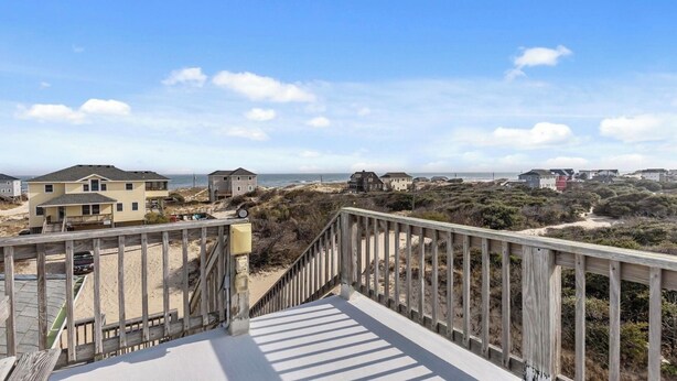 A wooden boardwalk leading to beach houses with a clear view of the ocean. - SALTED SHORES OBX formerlyPLAYING HOOKY, 5bed,Wild Horses,Pool,Hot Tub,4x4 Beach (Corolla)