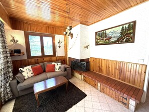 Ein gemütliches Wohnzimmer mit Sofa, Couchtisch und Kamin.
