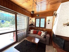 Ein gemütliches Wohnzimmer mit einer Couch, einem Couchtisch und einem Kamin.
