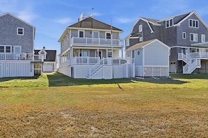 A residential area with multiple houses featuring front porches and attached garages. - Newly renovated 3BR/2BA coastal beach retreat-sweeping harbor & ocean views. (Scituate)