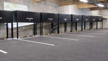 A parking garage with multiple parking bays, some marked as private, and a bicycle parked in one.