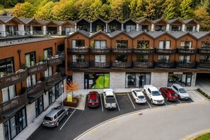 Un hotel de varios pisos con balcones, un estacionamiento y un letrero para la oficina de administración.