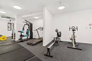 Ein Fitnessraum mit Cardiogeräten, Gewichten und Laufband.