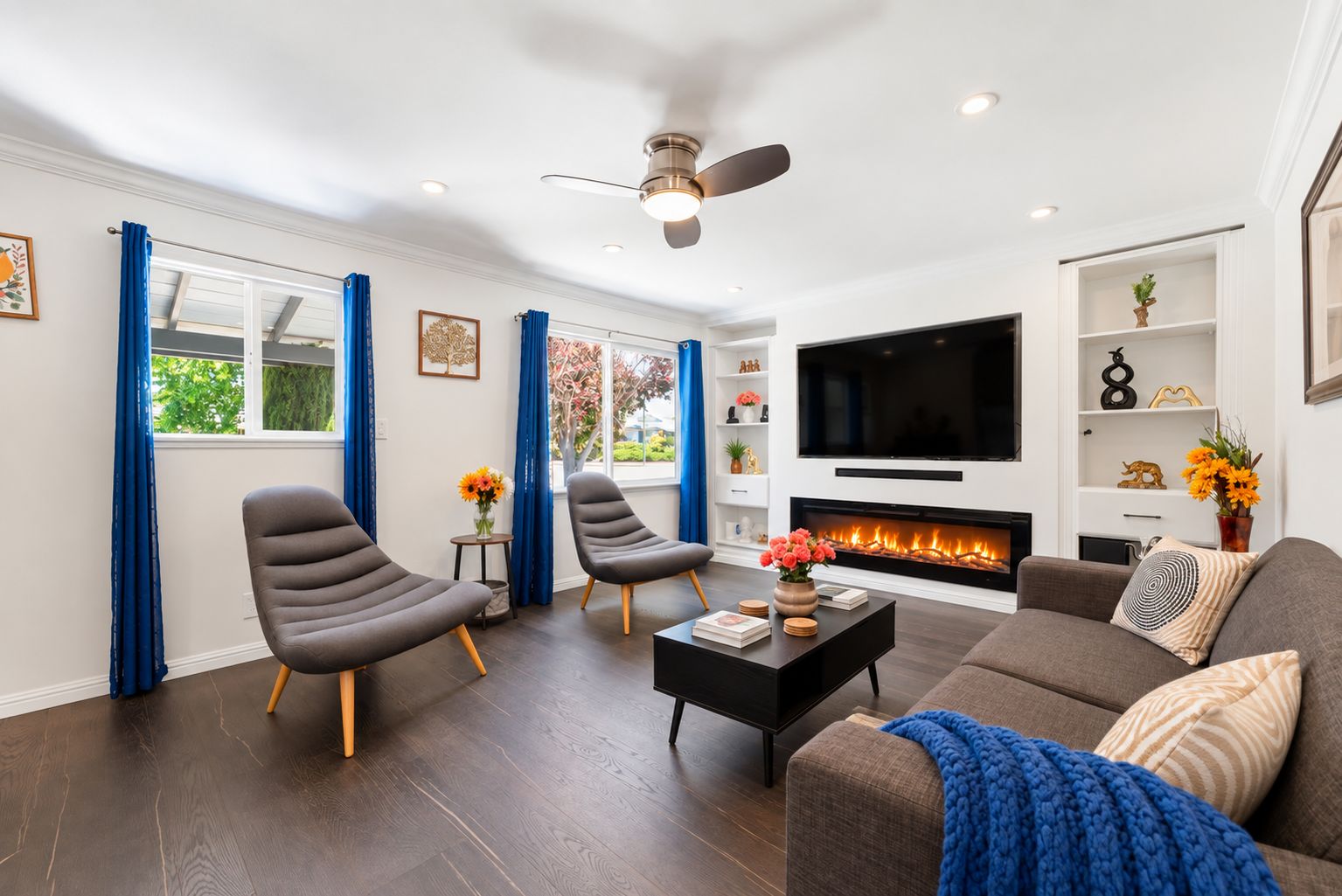 A modern living room with a fireplace, comfortable seating, and a flat-screen TV.